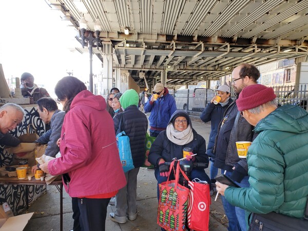 시카고 무궁화 노인 아파트 거주자들이 노숙자에게 빵과 커피를 제공하고 있다.(사진-시카고 무궁화 노인 아파트 김경자 권사 제공)