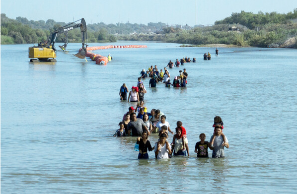 텍사스주로 진입하기 위해 중남미 밀입국 이민자들이 리오 그란데 강을 건너는 사이 이들을 저지하고자 부표가 설치되고 있다. (본지-로이터 게재 특약)